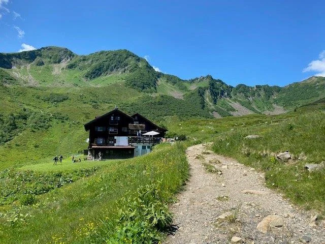 Blick auf eine Berghütte (Schwarzenkopfhütte) | © DAV Pfronten - Familiengruppe