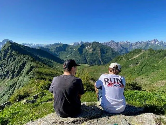 Zwei Personen blicken von einem Gipfel auf das umliegende Bergpanorama | © DAV Pfronten - Familiengruppe