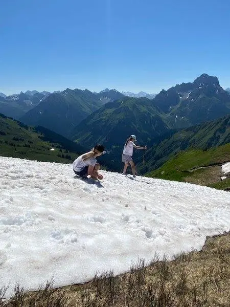 Ein Schneebrett mit spielenden Personen | © DAV Pfronten - Familiengruppe