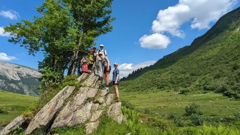 Sechs Mitglieder des DAV Pfronten auf einem Fels in einer günen Almlandschaft | © DAV Pfronten - Familiengruppe