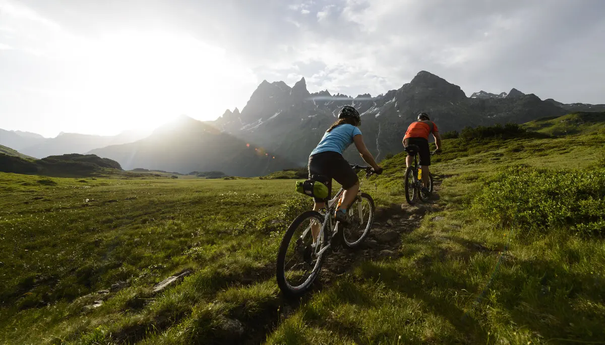 Zwei Mountainbiker*innen auf einem Trail in den Bergen. | © DAV/Wolfgang Ehn